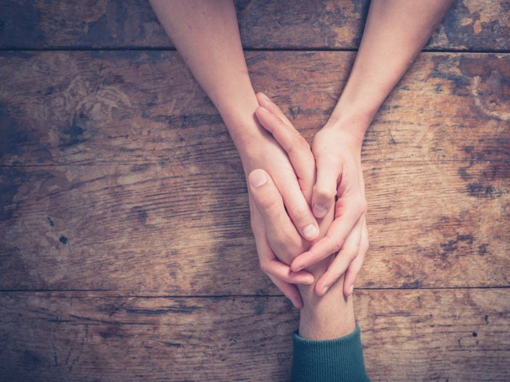 holding hands across a table