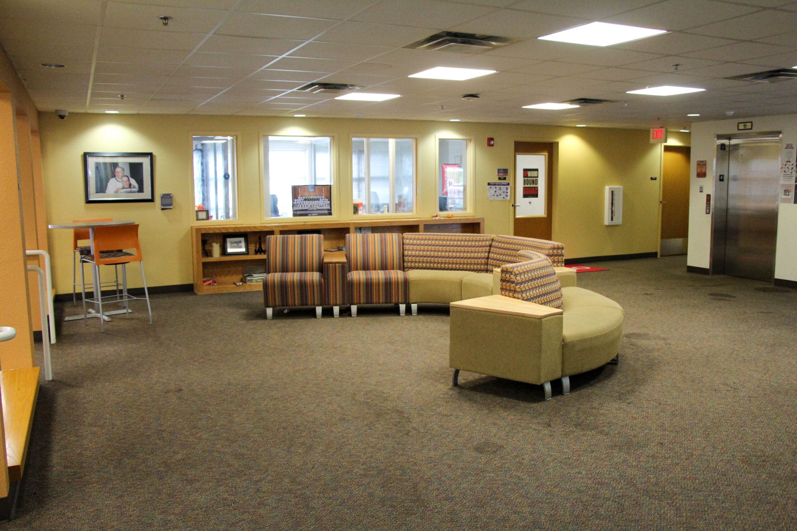 Campus common area with seating and open floor space for students