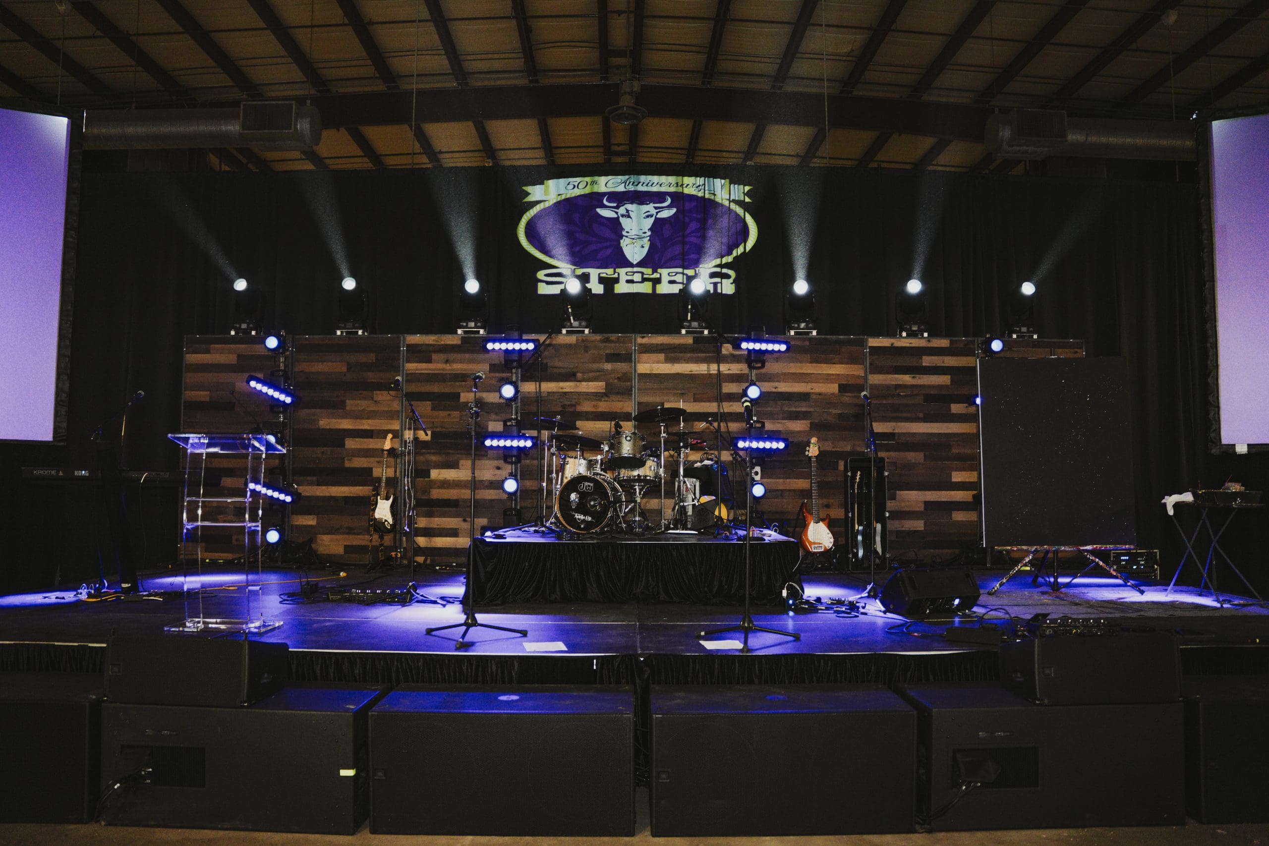 Stage setup with purple lighting and band equipment at the Avila University Steer Dinner