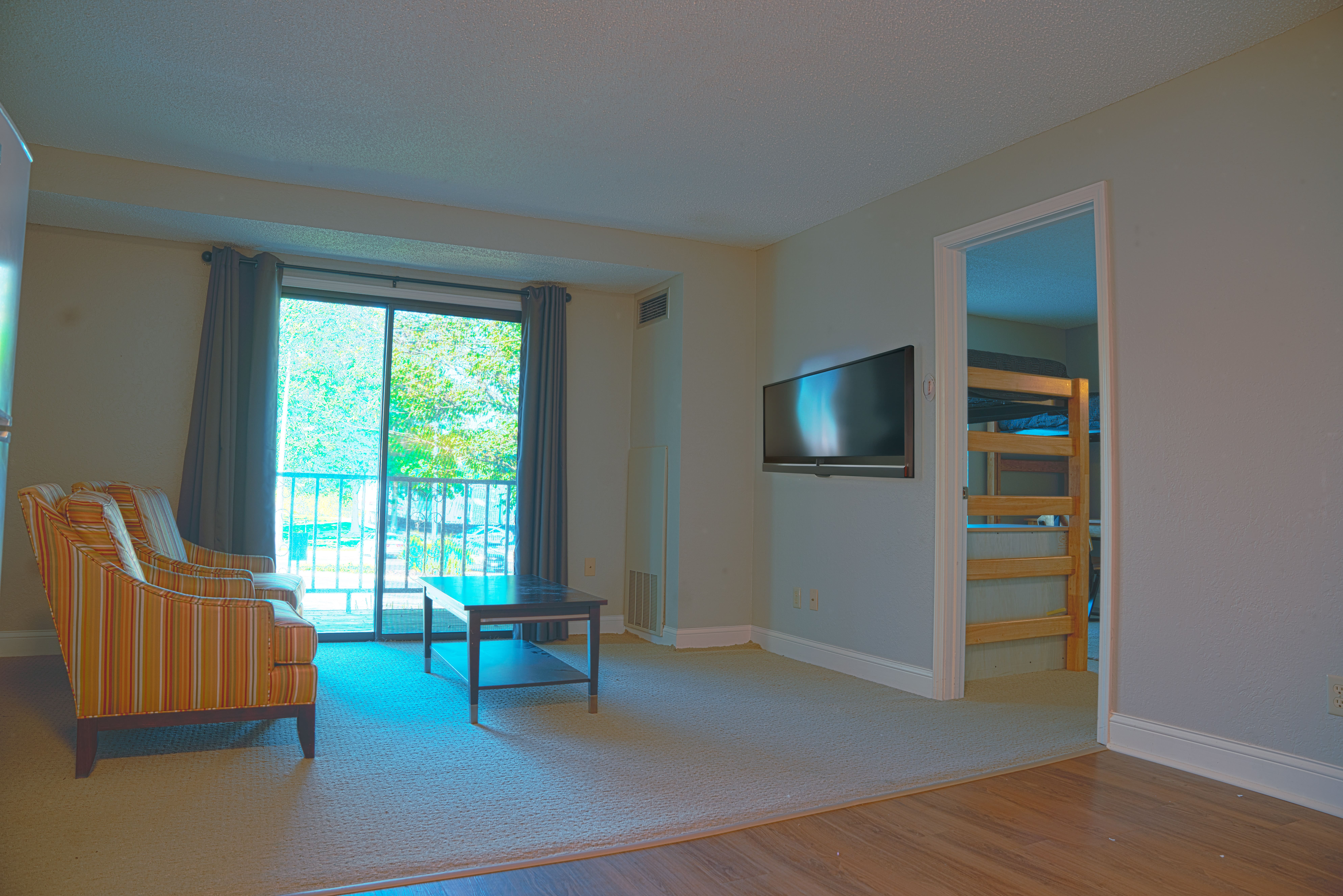 Cozy dorm-style bedroom with bed, lamp, and study space