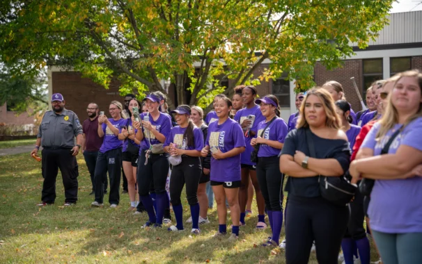 Avila University Eagles softball team and students gathered outdoors on campus in purple Eagles gear