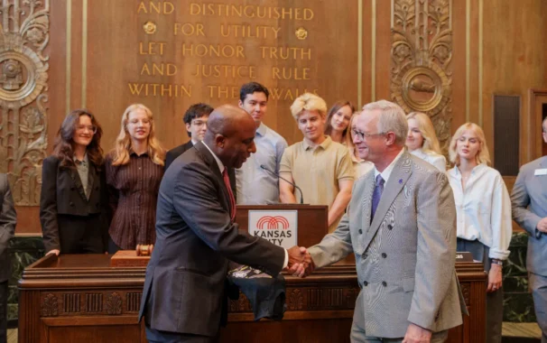 Avila University President Dr. Todd Pfannestiel shaking hands with Kansas City Mayor Quinton Lucas at Kansas City Hall, surrounded by INSPIRE International Exchange Program students during their July 2026 visit